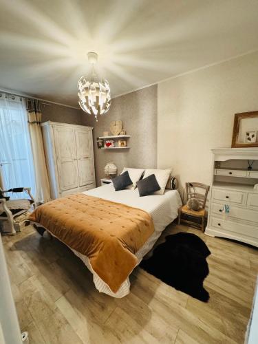 a bedroom with a large bed and a chandelier at Douceur de Vivre in Châteauroux