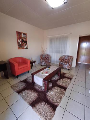 a living room with a table and two chairs at Augrabies De Oude Stoor Guesthouse in Augrabies