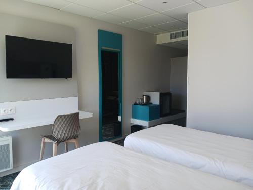 Ένα ή περισσότερα κρεβάτια σε δωμάτιο στο Brit Hotel Nantes Vigneux - L'Atlantel