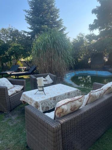 a backyard with two wicker chairs and a table and a pool at Domek wakacyjny in Lubin