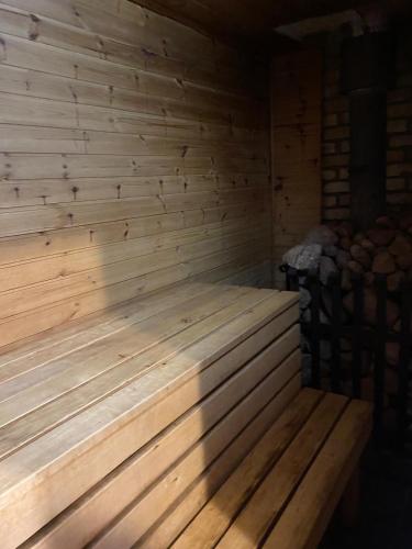 a wooden sauna with a bench in a room at Pirtsmāja Villa Marta in Cēsis