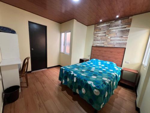 a bedroom with a bed with a blue blanket on it at C&M Exclusive Private Rooms in Quetzaltenango