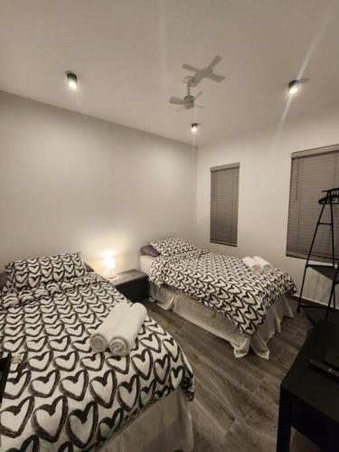 a bedroom with two beds and a ceiling fan at Los Cosos Mansion - Sleep 6 in Palm-Eagle Beach