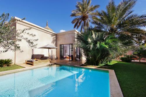 a swimming pool in front of a house at Palais Namaskar in Marrakech