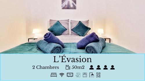 - une chambre avec un lit doté d'oreillers bleus et violets dans l'établissement Résidence Évasion & Élégance - Mulhouse, à Mulhouse