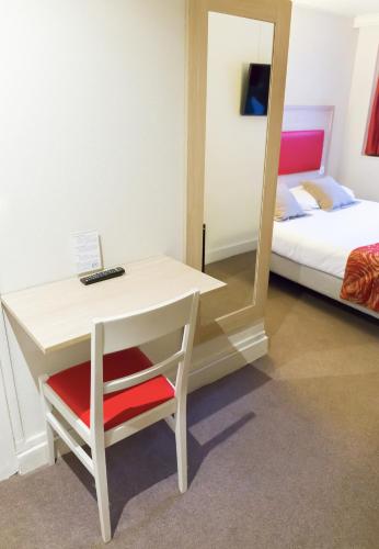 a room with a desk and a bed and a mirror at D'win in Paris