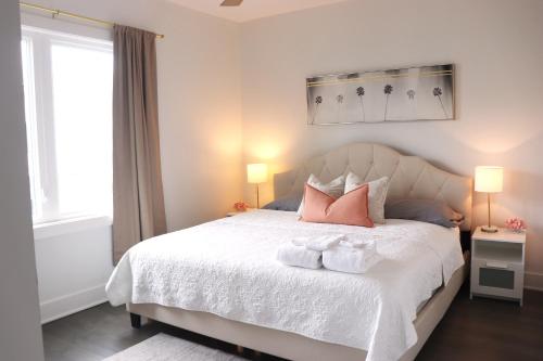 ナッシュビルにあるWelcome to Your East Nashville Oasis! Super Host!のベッドルーム1室(ピンクの枕2つ、白いベッド1台付)