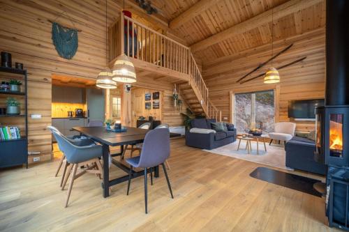 a dining room and living room in a log cabin at Moose Lodge - 6p - With Sauna & Water View in Vradal