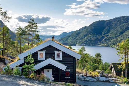 a small log cabin with a view of a lake at Moose Lodge - 6p - With Sauna & Water View in Vradal