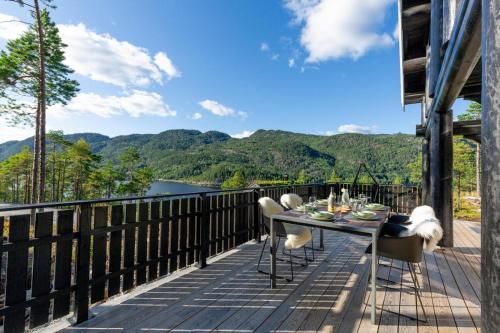 a table and chairs on a deck with a view at Moose Lodge - 6p - With Sauna & Water View in Vradal