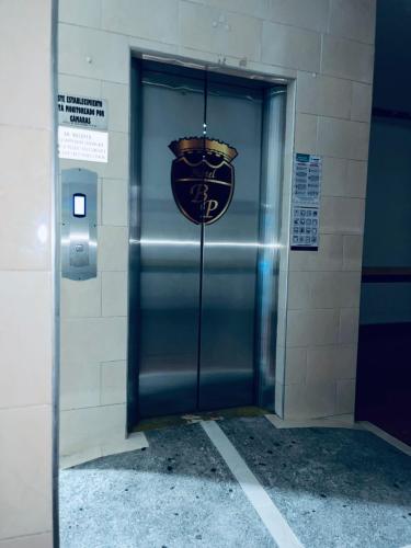 a metal door in a building with a sign on it at Hotel Bucarica Plaza in Bucaramanga