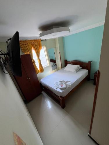 a bedroom with a bed and a flat screen tv at Hotel Bucarica Plaza in Bucaramanga