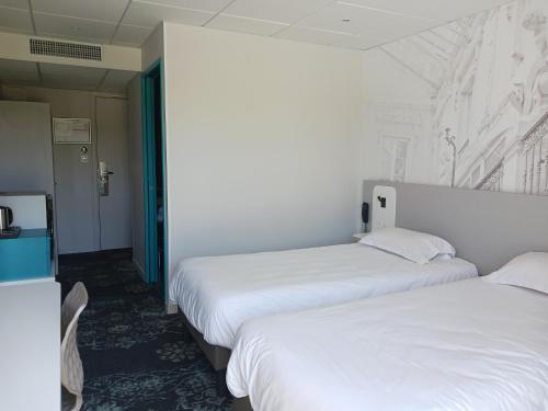 Ένα ή περισσότερα κρεβάτια σε δωμάτιο στο Brit Hotel Nantes Vigneux - L'Atlantel