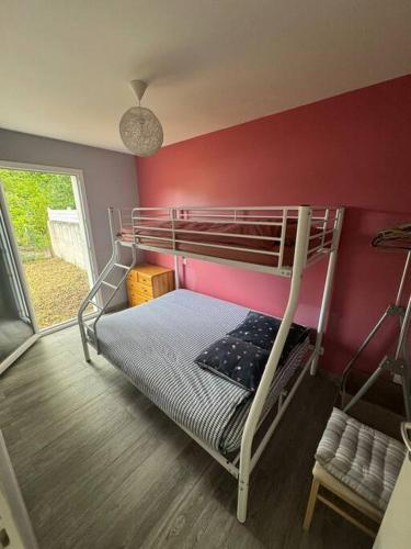 un lit superposé dans une chambre avec un mur rouge dans l'établissement Maison 5 chambres avec piscine, à Mauret