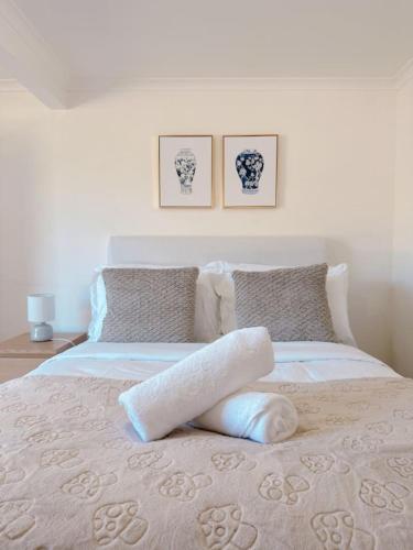 a bedroom with a bed with two pillows at Comfy unit near Garden City Westfield Street Parking in Brisbane