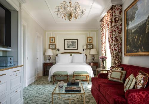 a bedroom with a bed and a red couch at Four Seasons Hotel Firenze in Florence
