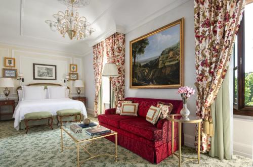 a bedroom with a bed and a red couch at Four Seasons Hotel Firenze in Florence