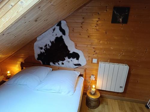 a bedroom with a bed with a cow on the wall at Charmant Chalet de montagne in Picherande