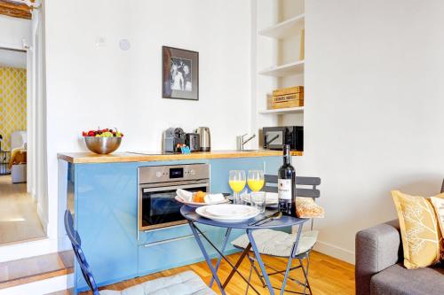 une petite cuisine avec une table et des verres à vin dans l'établissement Bluestay 283 - Superbe Appartement dans le Marais, à Paris