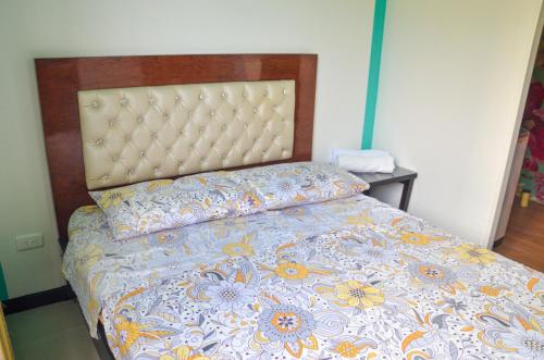 a bedroom with a bed with a floral bedspread at SANDY APARTAMENTO in Santa Rosa de Cabal