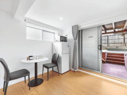 a kitchen with a table and chairs and a refrigerator at 1 Bedroom Unit near Highway Transports n Shops in Brisbane