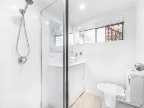 a white bathroom with a shower and a toilet at 1 Bedroom Unit near Highway Transports n Shops in Brisbane