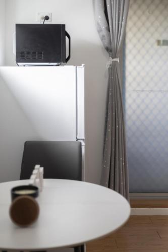 a kitchen with a white table and a refrigerator at 1 Bedroom Unit near Highway Transports n Shops in Brisbane