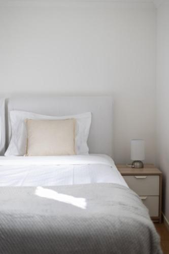a bedroom with a white bed and a night stand at 1 Bedroom Unit near Highway Transports n Shops in Brisbane