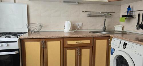 a kitchen with a sink and a washing machine at BELTA*S APARTMENTS in Chişinău