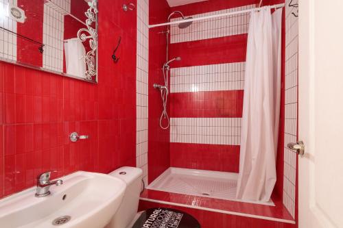 ein rot gefliestes Bad mit einem Waschbecken und einer Dusche in der Unterkunft La torre in Alicante