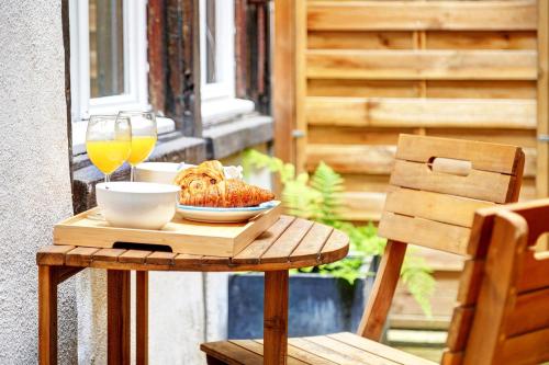 une table avec une assiette de nourriture et un verre de vin dans l'établissement Bluestay 282 - Superbe appartement avec terrasse, à Paris