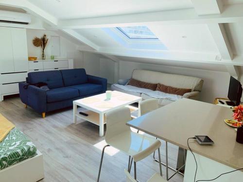a living room with a blue couch and a table at CANNES CENTRE proche PLAGE CROISETTE PALAIS DES FESTIVALS in Cannes