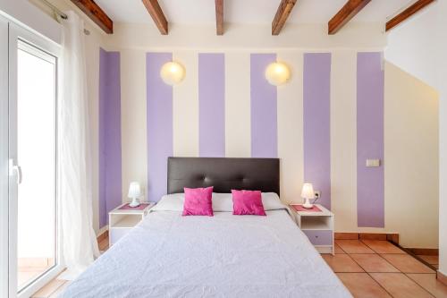 ein Schlafzimmer mit einem großen Bett mit rosa Kissen in der Unterkunft La torre in Alicante