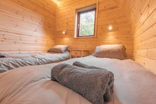 a bedroom with two beds in a wooden cabin at The Bell Inn in Wendens Ambo