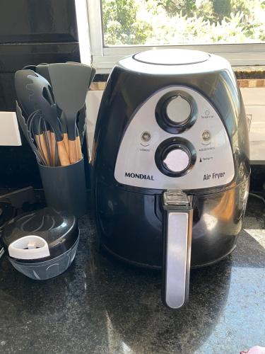 a toaster sitting on a counter next to a cup of knives at Casa de praia com vista para o mar in São Sebastião