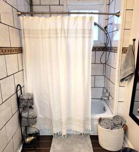 a bathroom with a shower curtain and a tub at Apple Hill Bungalow, Family and PET Friendly! in Bristol