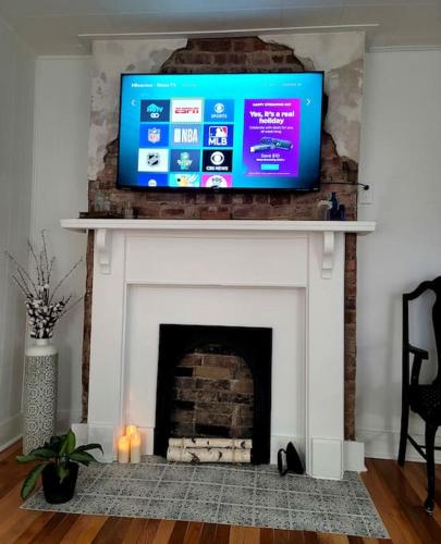 a fireplace with a tv on top of it at Apple Hill Bungalow, Family and PET Friendly! in Bristol