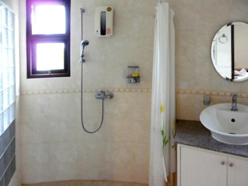 La salle de bains est pourvue d'une douche et d'un lavabo. dans l'établissement Mango Spa & Resort, à Hua Hin
