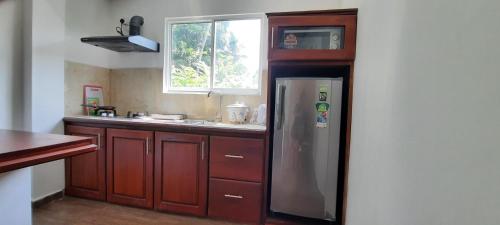 a kitchen with a stainless steel refrigerator and a window at Tulip Heights Apartment in Daulagala