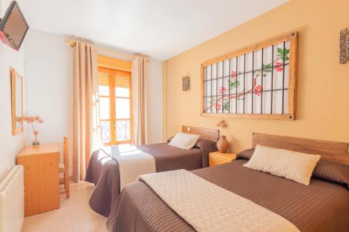 a bedroom with two beds and a stained glass window at Hotel Palacio in Cogolludo