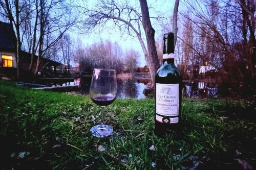 a bottle of wine sitting in the grass next to a glass at Garden room in green surroundings, sleeps 2 in Roeselare