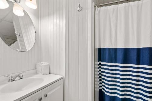 a bathroom with a sink and a shower curtain at Cozy Retreat on Commercial Street for 2 in Provincetown