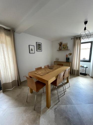 une salle à manger avec une table et des chaises en bois dans l'établissement Maisonnette typique de village, à Bastelica