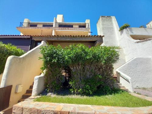 Un edificio con algunos arbustos delante de un edificio. en Marines de Cogolin, studio neuf face à la plage, climatisation, wifi, terrasse, proche St Tropez, en Cogolin
