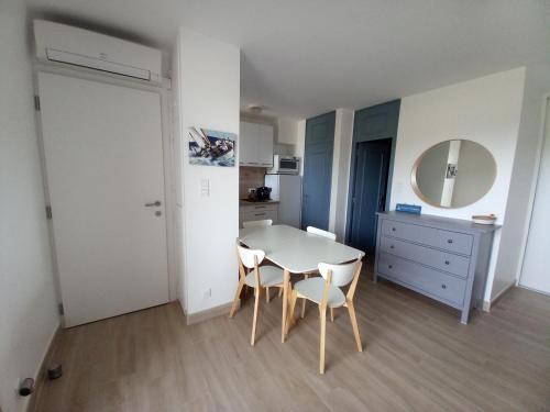 une cuisine avec une table et des chaises dans une pièce dans l'établissement Marines de Cogolin, studio neuf face à la plage, climatisation, wifi, terrasse, proche St Tropez, à Cogolin