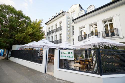 a restaurant with umbrellas in front of a building at Carol Park View in Bucharest