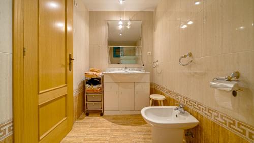 a bathroom with a white toilet and a sink at Piso Atrium de 1 dormitorio in Villajoyosa