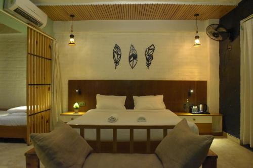 a bedroom with a bed and a chair and lights at Julley Commune Rishikesh in Rishīkesh