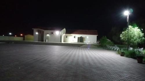 a white building with a street light at night at Thefarm rak in Al Ḩamrānīyah