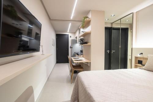 a bedroom with a bed and a desk and a table at Way Tambaú #P2 - Triplo deluxe por Carpediem in Tambaú
